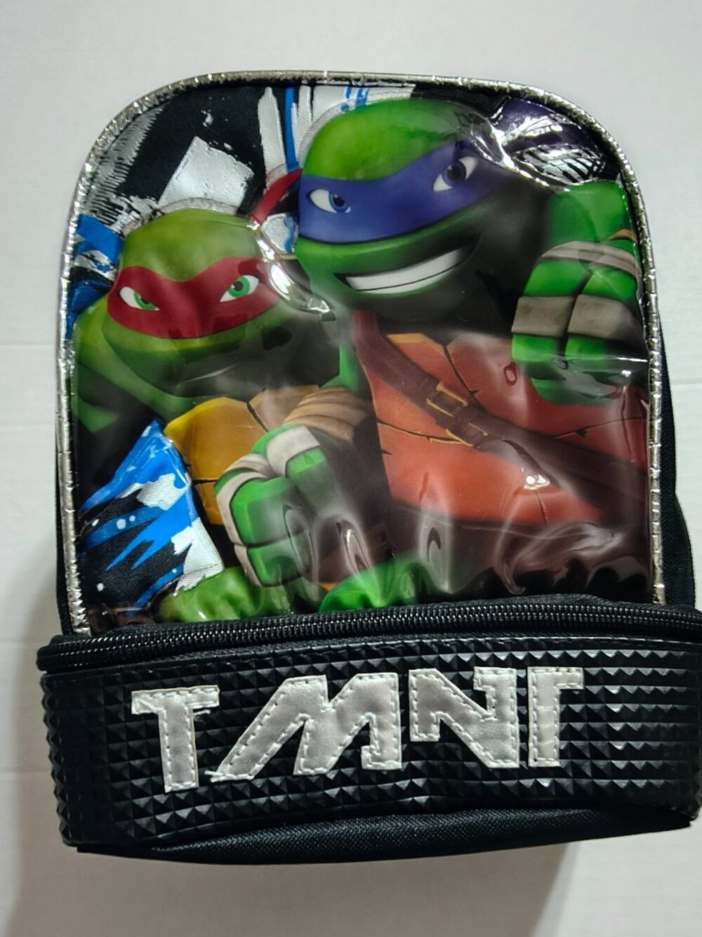 Soft lunch bag with bottom compartment for additional storage.